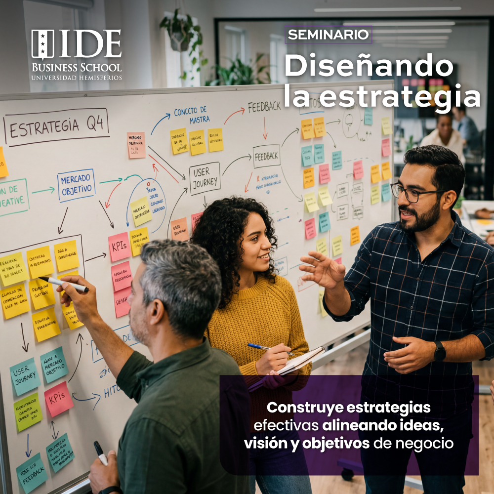 Equipo de trabajo discutiendo estrategias frente a una pizarra llena de notas adhesivas en un seminario de diseño de estrategia en IDE Business School.